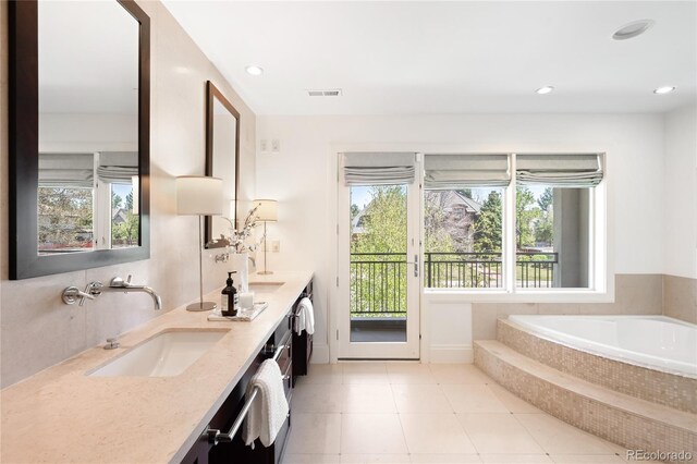 full bathroom featuring healthy amount of natural light, double vanity, a garden tub, recessed lighting, and tile patterned floors