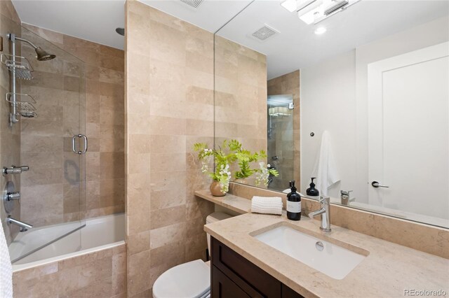 bathroom with tiled shower / bath combo, toilet, and vanity
