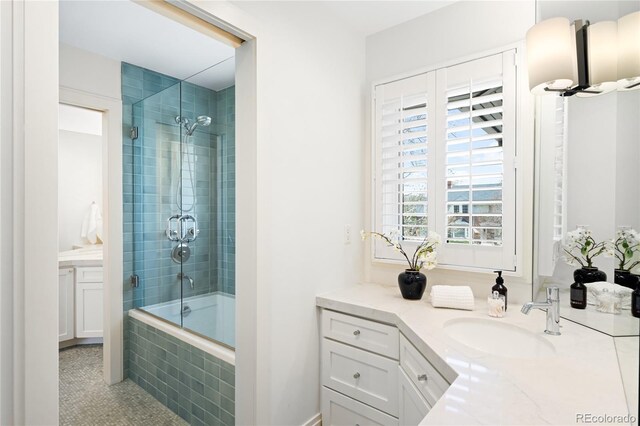 full bathroom featuring tiled shower / bath, vanity, and tile patterned flooring