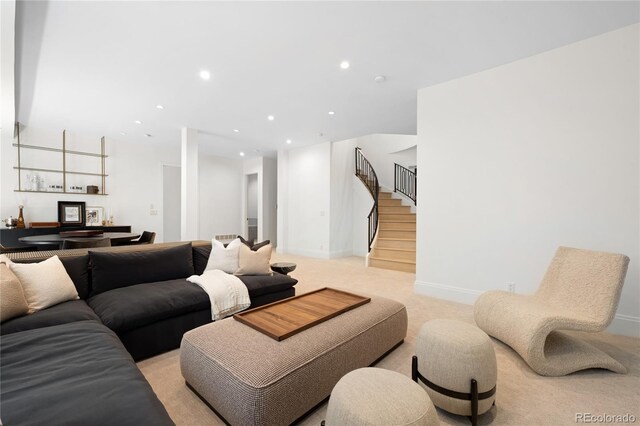 living room with stairs, light carpet, recessed lighting, and baseboards