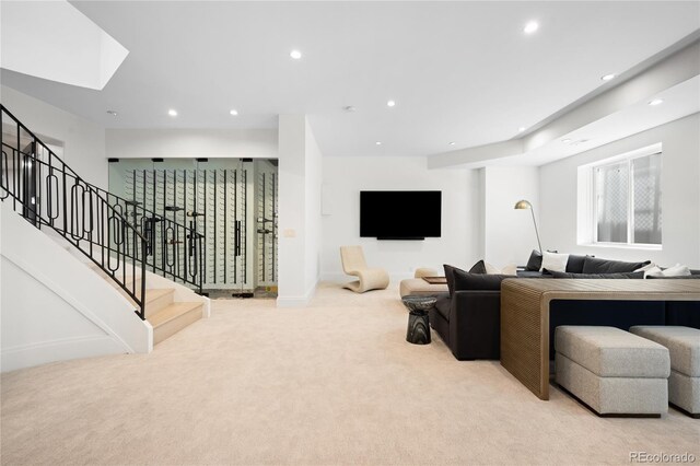 living area with light carpet, recessed lighting, a skylight, stairway, and baseboards