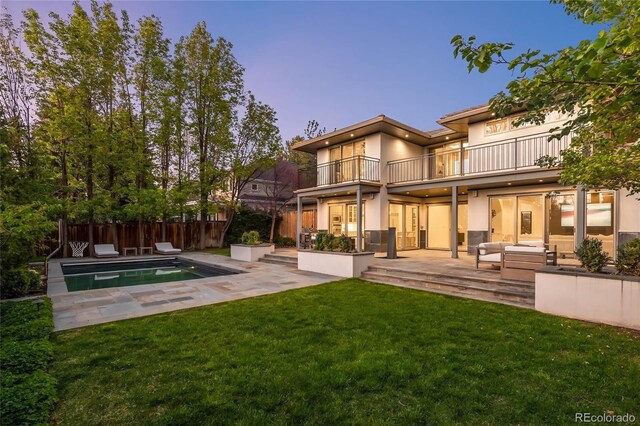 back of house featuring a balcony, stucco siding, an outdoor hangout area, and a patio area