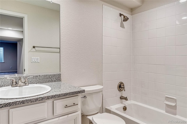 full bathroom with vanity, tiled shower / bath combo, and toilet