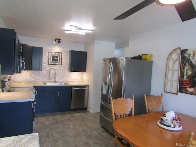 kitchen with blue cabinetry, appliances with stainless steel finishes, decorative backsplash, and sink