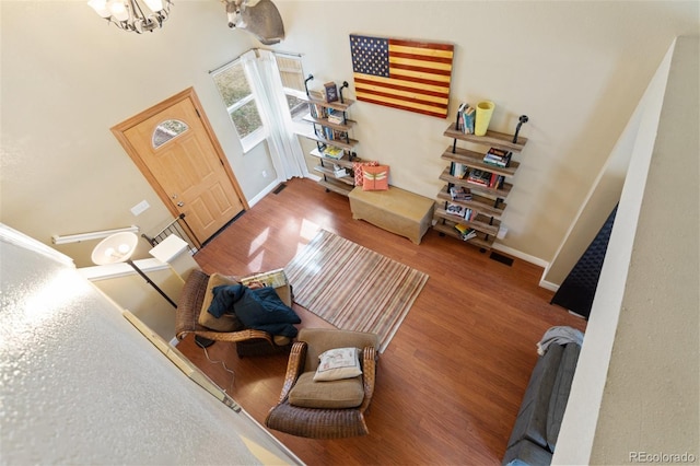 foyer entrance featuring a notable chandelier, baseboards, and wood finished floors