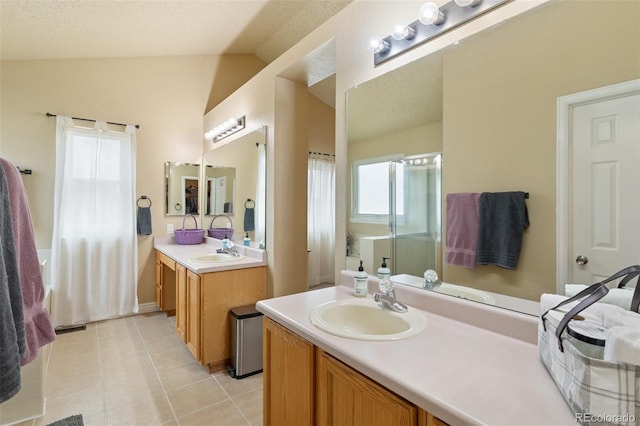 bathroom featuring tile patterned floors, two vanities, lofted ceiling, and a sink