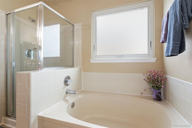 full bathroom featuring a bath and a stall shower