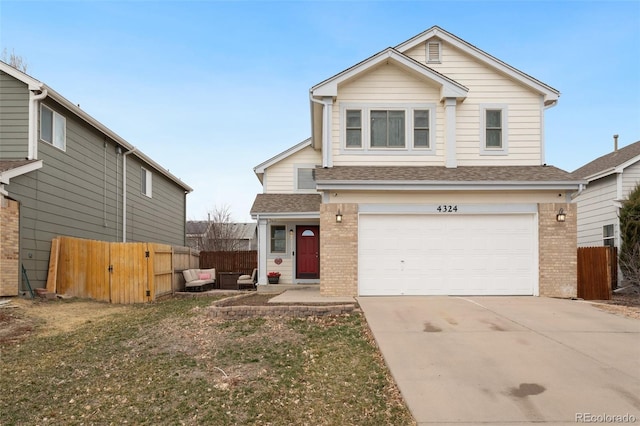 traditional-style home featuring brick siding, an attached garage, concrete driveway, and fence