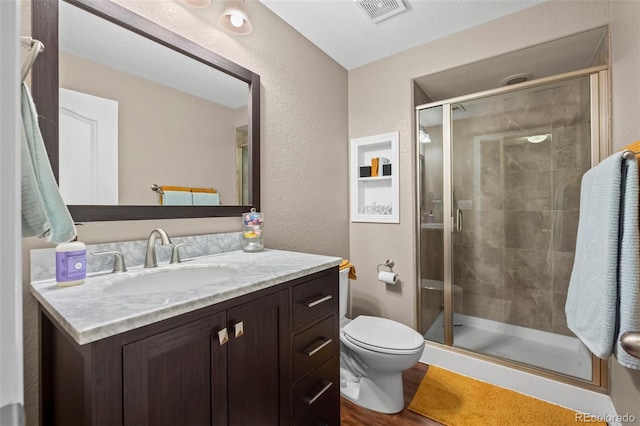 9957 Quintero St, Commerce City, CO 80022 - bathroom with vanity, a stall shower, a textured wall, and wood finished floors
