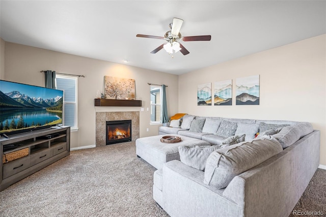 carpeted living room featuring ceiling fan and a tiled fireplace