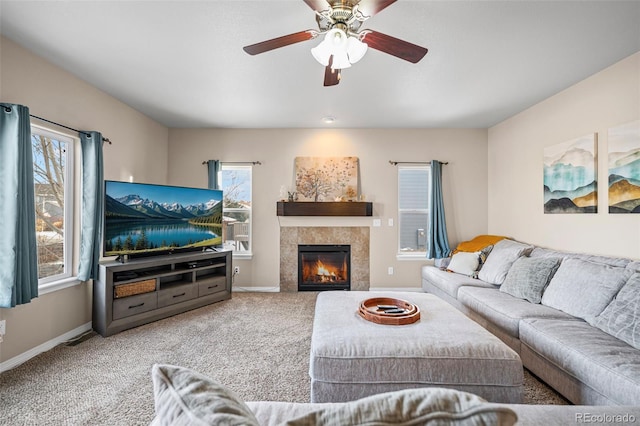 carpeted living room featuring a wealth of natural light, a tile fireplace, and ceiling fan