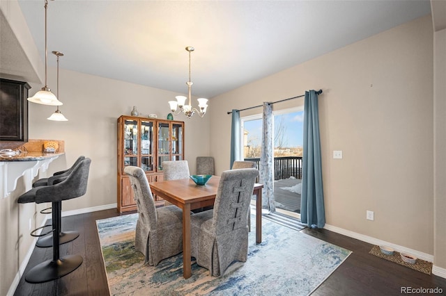 dining area featuring dark hardwood / wood-style flooring and an inviting chandelier