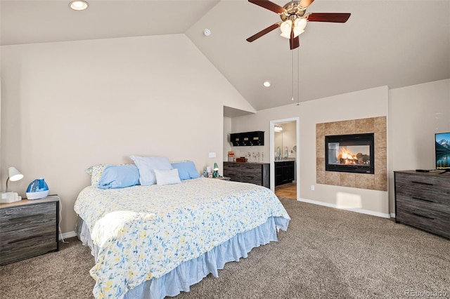 bedroom featuring carpet floors, a tile fireplace, ceiling fan, and ensuite bathroom