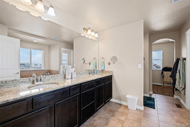 bathroom featuring vanity, tile patterned flooring, and a textured ceiling