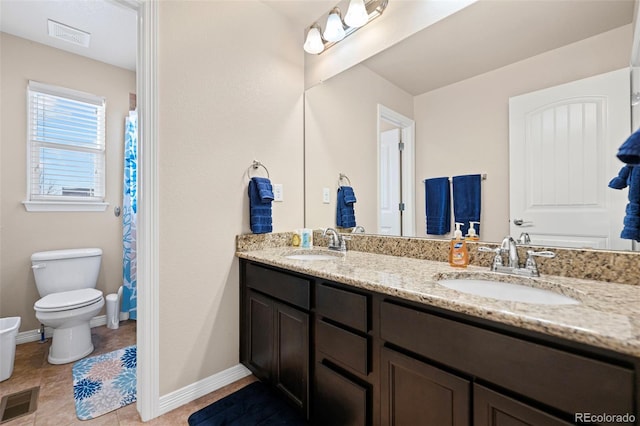 bathroom featuring tile patterned flooring, vanity, and toilet