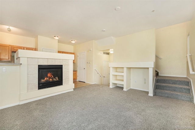 5255 Memphis St Unit 315, Denver, CO 80239 - unfurnished living room with light carpet, a fireplace, stairway, and baseboards