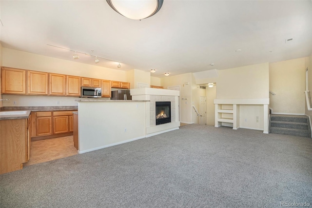 5255 Memphis St Unit 315, Denver, CO 80239 - unfurnished living room featuring light colored carpet, a sink, a tile fireplace, stairs, and baseboards