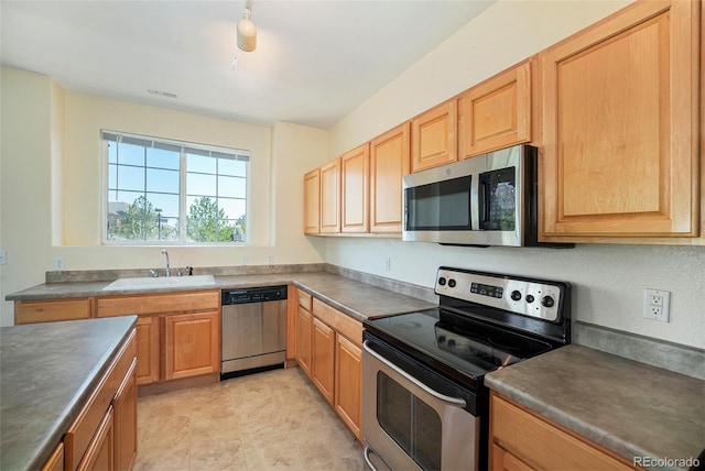 5255 Memphis St Unit 315, Denver, CO 80239 - kitchen featuring stainless steel appliances, a sink, dark countertops, and light brown cabinets