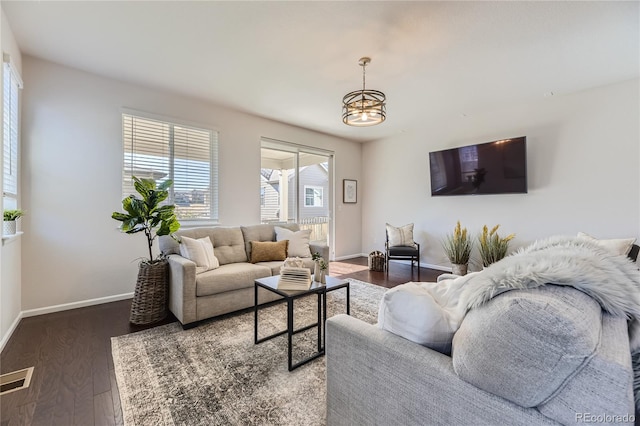 living room featuring a notable chandelier and dark hardwood / wood-style floors