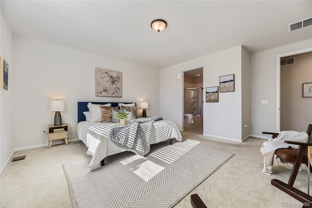 bedroom with connected bathroom and light carpet