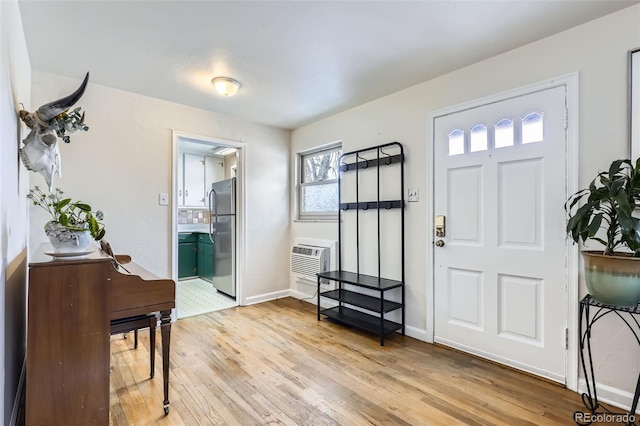 foyer entrance featuring light hardwood / wood-style flooring and a wall unit AC