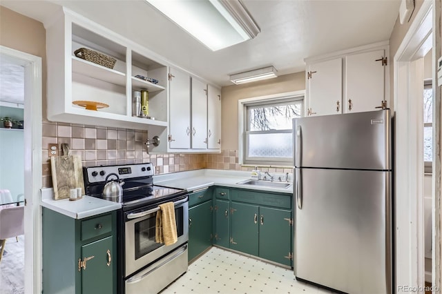 kitchen with white cabinets, appliances with stainless steel finishes, tasteful backsplash, sink, and green cabinetry