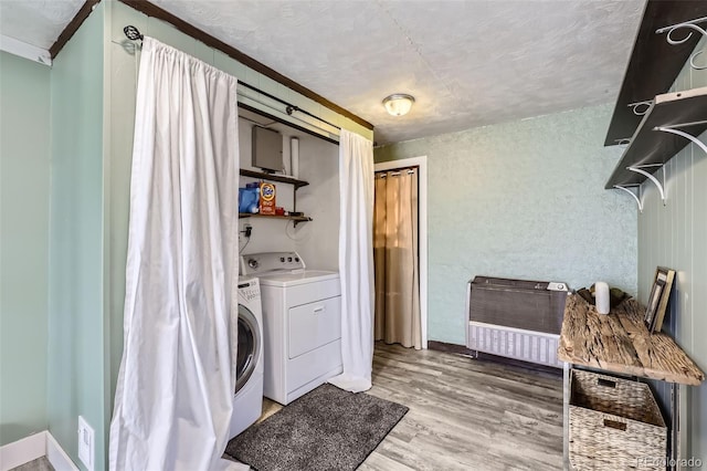 laundry room with light hardwood / wood-style flooring, separate washer and dryer, and a textured ceiling