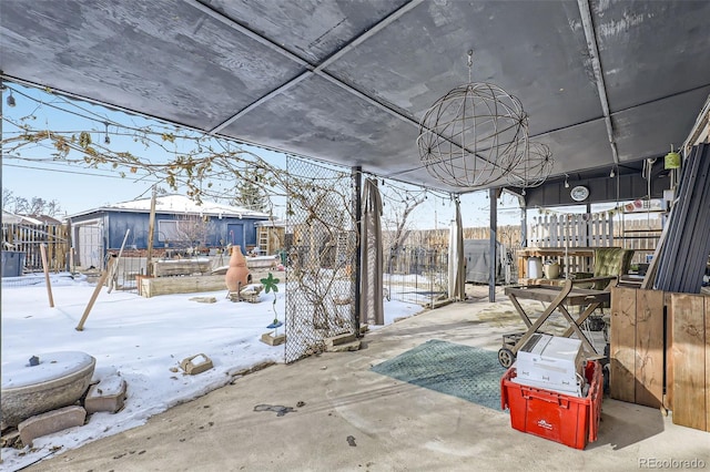 snow covered patio with a storage unit