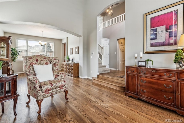 sitting room featuring hardwood / wood-style flooring and a towering ceiling