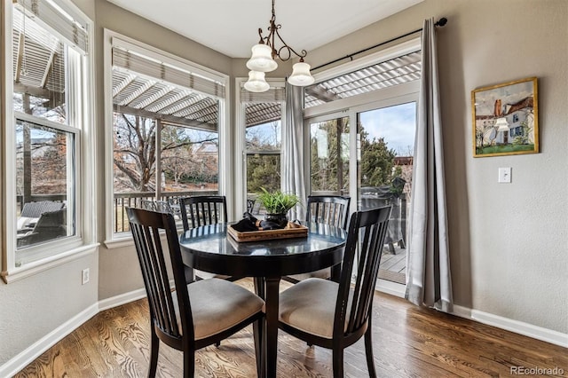 dining room featuring an inviting chandelier, dark hardwood / wood-style floors, and a healthy amount of sunlight