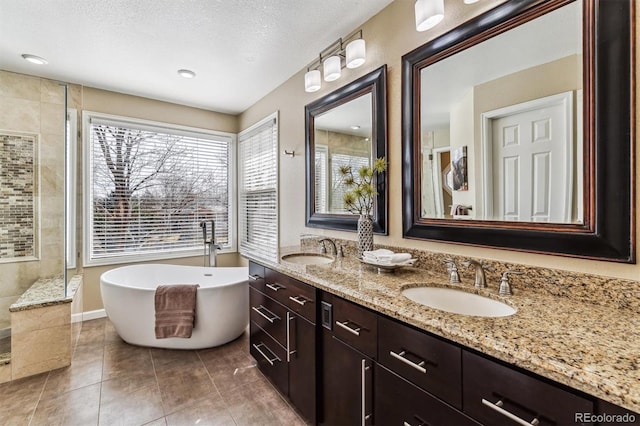 bathroom with tile patterned flooring, vanity, separate shower and tub, and a textured ceiling