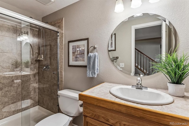 bathroom with vanity, an enclosed shower, and toilet