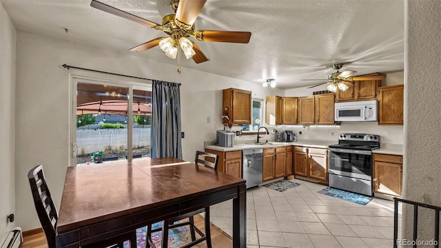 3102 Pine Cone Ct, Grand Junction, CO 81504 - kitchen with stainless steel appliances, ceiling fan, baseboard heating, light countertops, and a textured ceiling