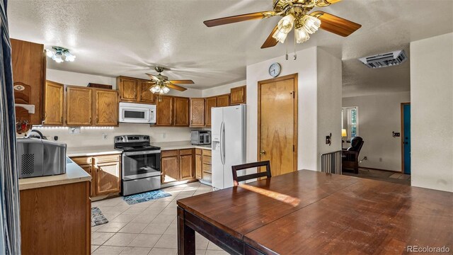3102 Pine Cone Ct, Grand Junction, CO 81504 - kitchen featuring white appliances, a ceiling fan, light tile patterned flooring, light countertops, and brown cabinetry