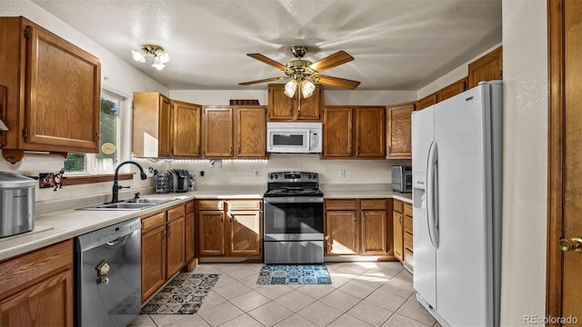 3102 Pine Cone Ct, Grand Junction, CO 81504 - kitchen with appliances with stainless steel finishes, a sink, brown cabinets, and light countertops