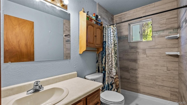 3102 Pine Cone Ct, Grand Junction, CO 81504 - full bath with toilet, vanity, a tile shower, and a textured wall
