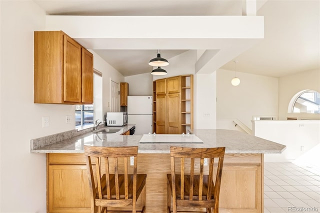 kitchen with white refrigerator, plenty of natural light, sink, and kitchen peninsula