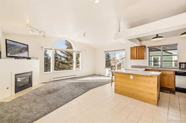 kitchen featuring sink, baseboard heating, stainless steel appliances, light carpet, and vaulted ceiling