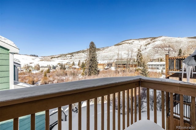 snow covered back of property with a mountain view