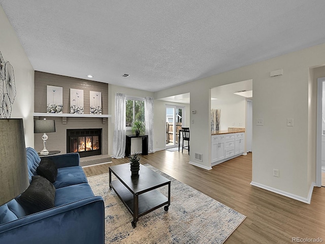 living room with light hardwood / wood-style flooring and a textured ceiling