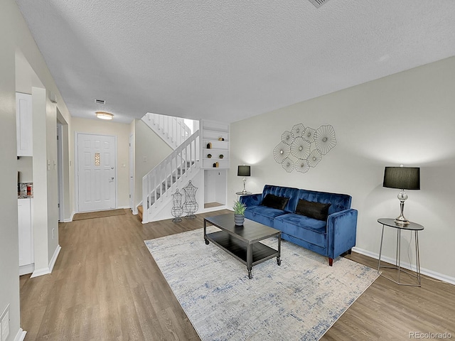 living room featuring a textured ceiling and wood-type flooring