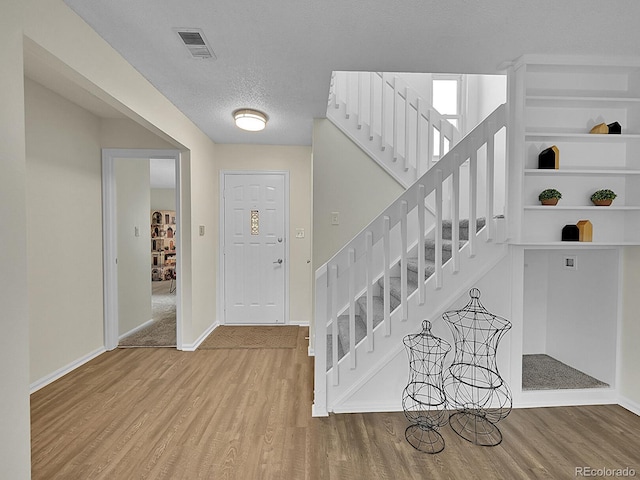 foyer with a textured ceiling and hardwood / wood-style floors