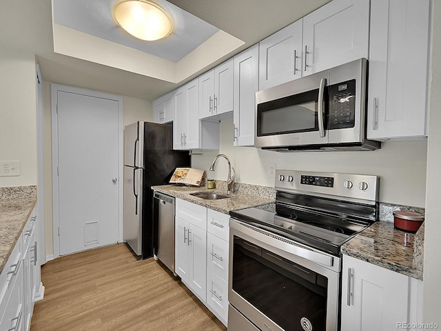 kitchen featuring sink, light hardwood / wood-style flooring, stainless steel appliances, light stone countertops, and white cabinets