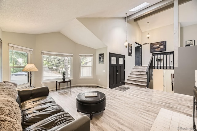 7727 Maroon Peak, Littleton, CO 80127 - living area featuring a skylight, wood finished floors, high vaulted ceiling, and beamed ceiling