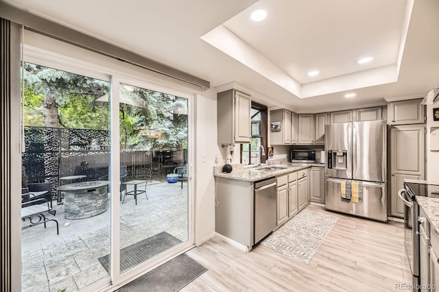 7727 Maroon Peak, Littleton, CO 80127 - kitchen with stainless steel appliances, gray cabinets, recessed lighting, a raised ceiling, and light wood-style floors