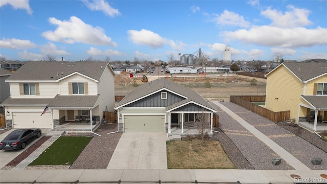 view of front of house with driveway, fence, stone siding, and a porch