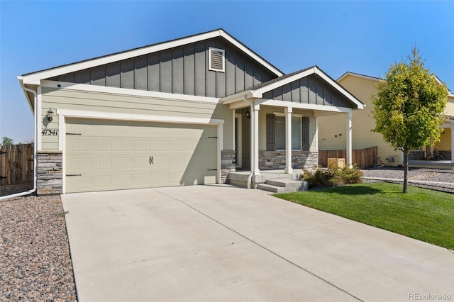 craftsman house with board and batten siding, stone siding, a porch, an attached garage, and concrete driveway