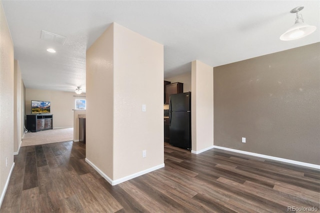 empty room featuring dark wood-type flooring, baseboards, recessed lighting, and a fireplace