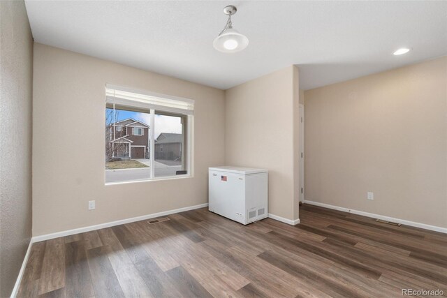 unfurnished room with wood finished floors, baseboards, and recessed lighting