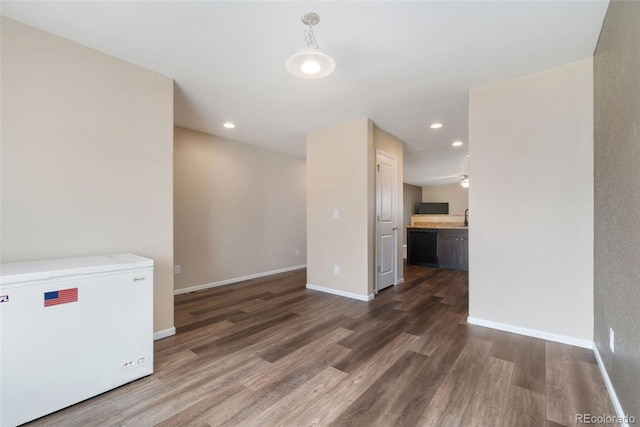 unfurnished room featuring wood finished floors, recessed lighting, and baseboards
